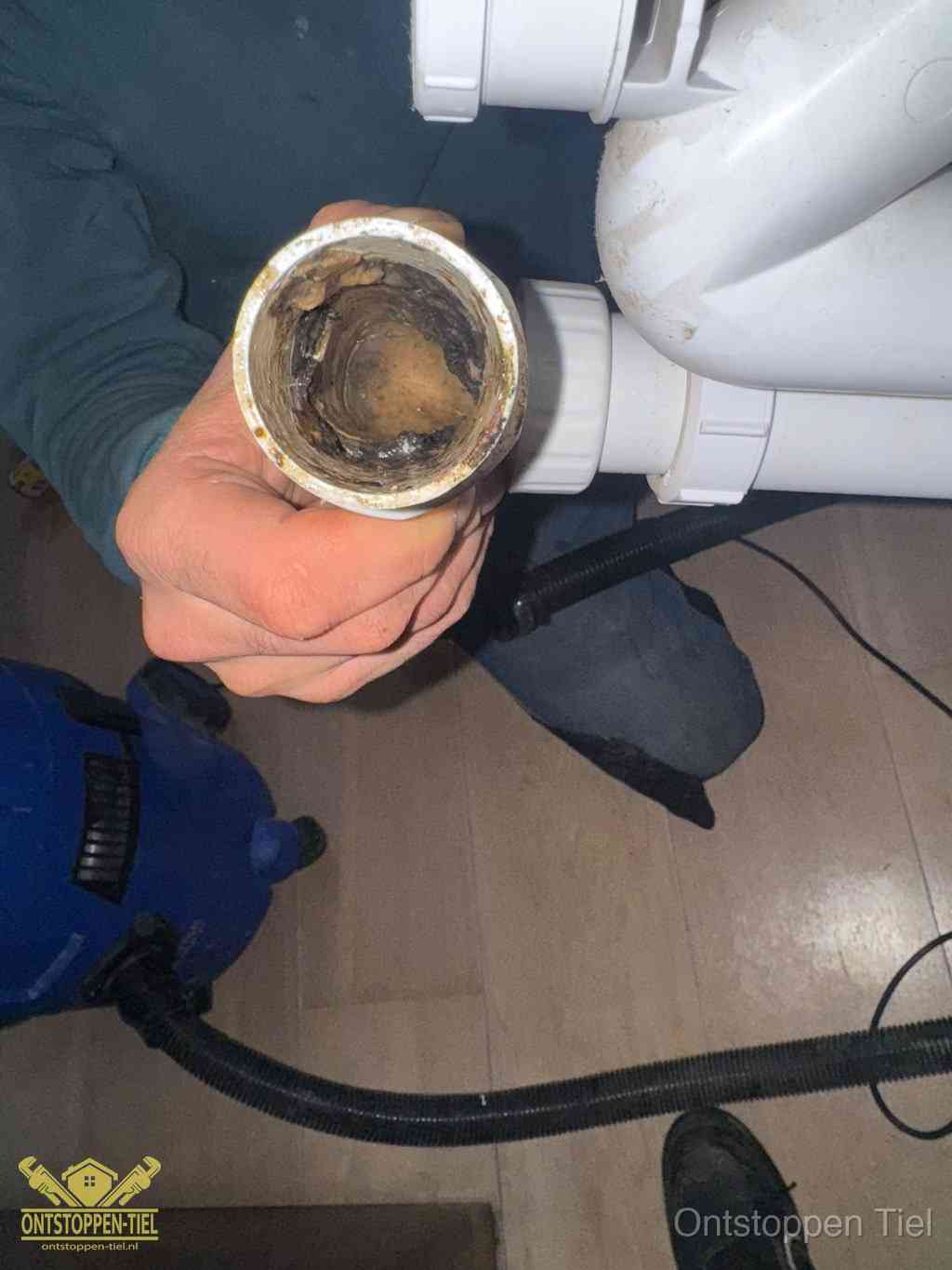 Een losgekoppeld afvoerbuisstuk dat van binnen volledig is dichtgeslibd, het gevolg van een verstopping te lang laten zitten in Tiel