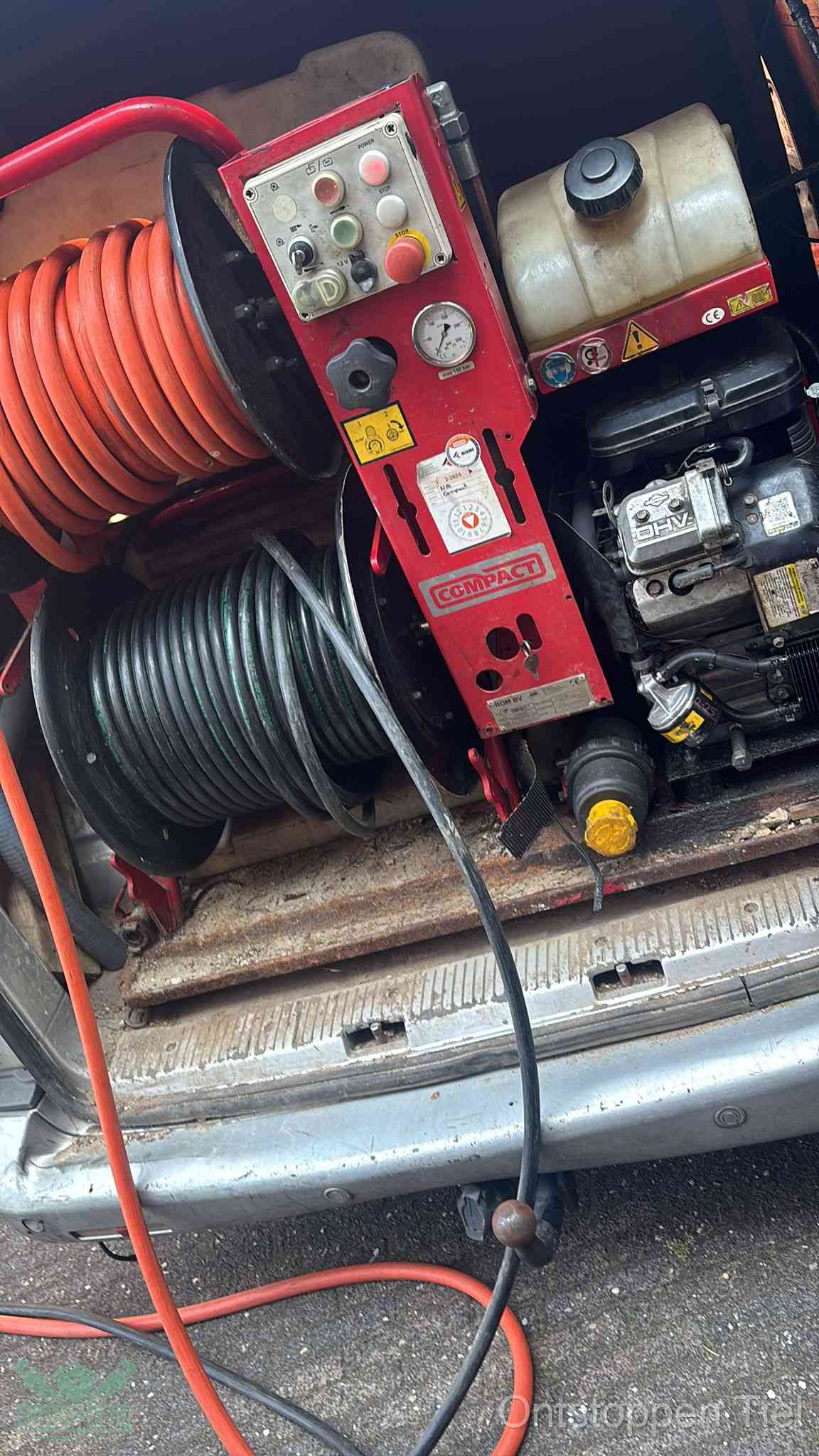 Een rood hogedruk-rioolreinigingstoestel in de laadbak van de bedrijfsbus, apparatuur voor een hardnekkige afvoerverstopping in Tiel