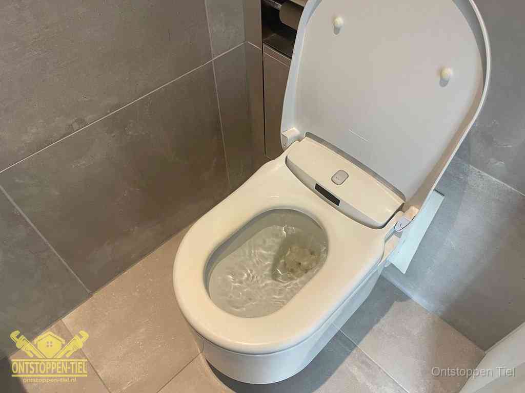 Een toiletpot vol troebel water met drijvend papier en restanten, de meest voorkomende oorzaak van een verstopte wc in Tiel
