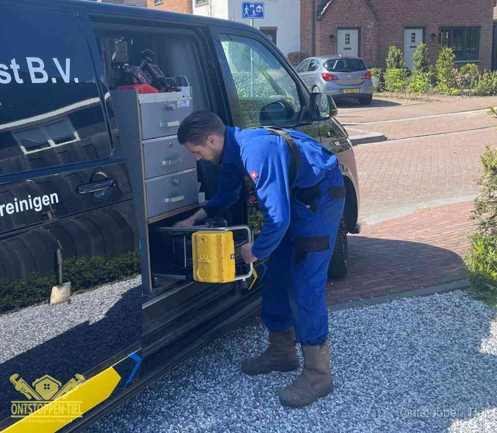 Een monteur pakt apparatuur uit de bedrijfsbus voor service aan huis, het moment om een professional in te schakelen voor een verstopte wc in Tiel