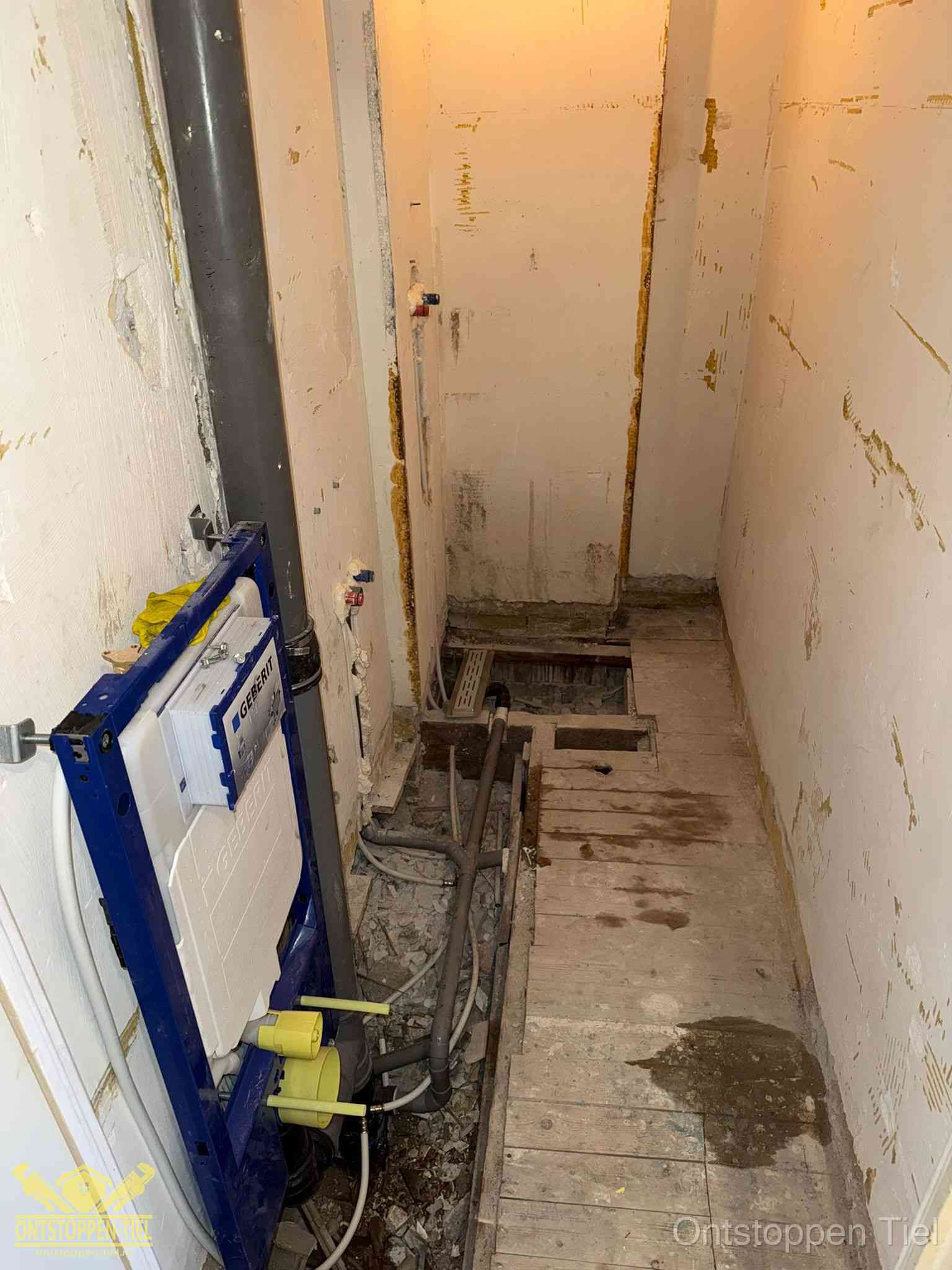 Een opgebroken toiletruimte tijdens renovatie met een Geberit inbouwreservoir en blootliggende oude afvoerleidingen, typisch voor oudere woningen in Tiel